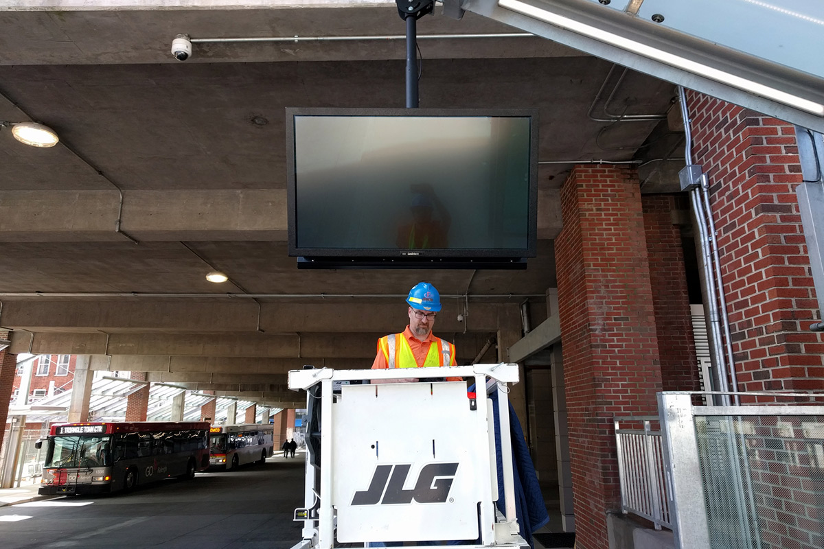 Image of one of our specialists installing digital signage